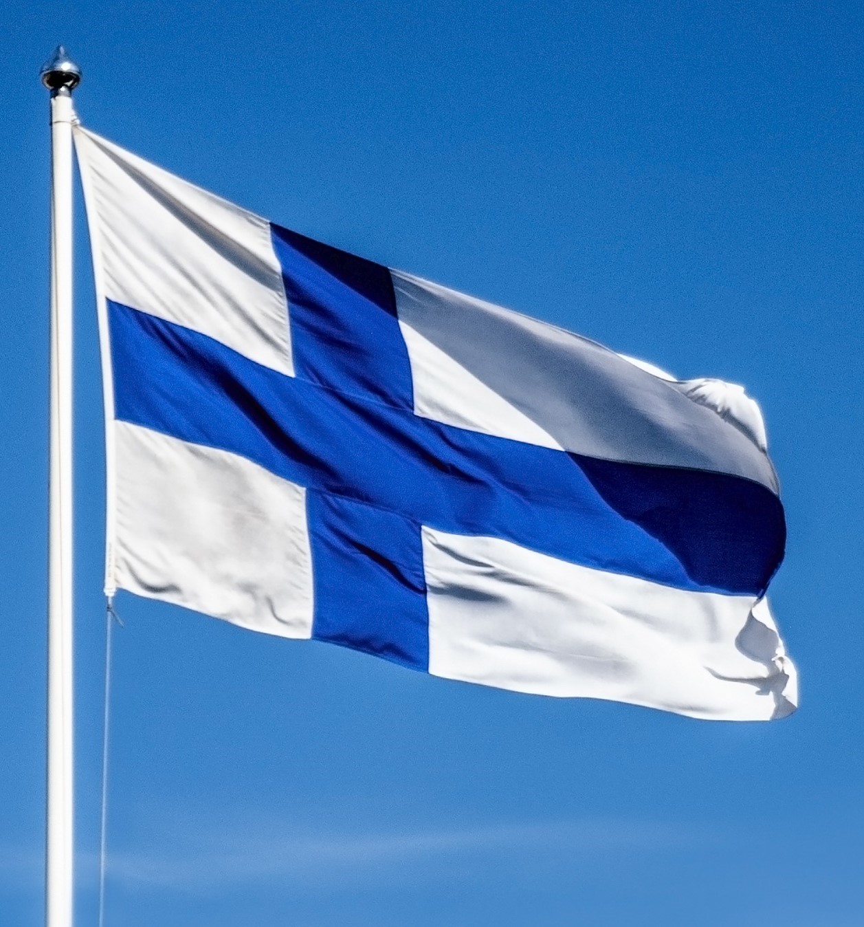 Suomen lippu liehuu taivaalla.