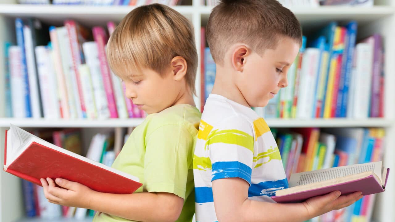 Kaksi poikaa lukee kirjaa